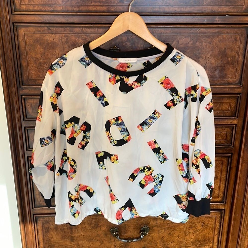Lush woman’s long sleeve blouse with letters and flowers all of the top